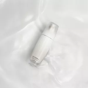 Micro Essence in Lotion bottle on background of its silky texture